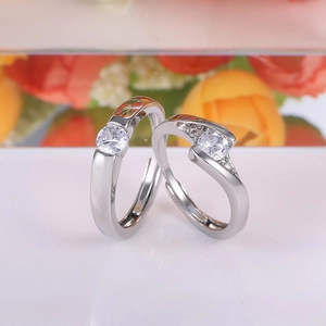 Elegant silver couples ring set with round zircon stones on a romantic floral background