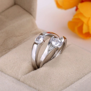 Elegant silver couple rings with sparkling zircon stones in a beige velvet jewelry box