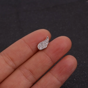Macro detail of a silver angel wing stud earring with sparkling clear cubic zirconia
