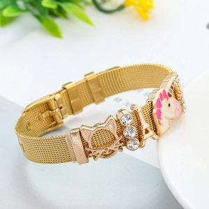 Close-up of golden mesh bracelet with unicorn, cat and Eiffel Tower charms on white base