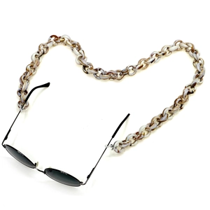 Macro detail of acrylic tortoiseshell glasses chain arranged in a heart shape layout
