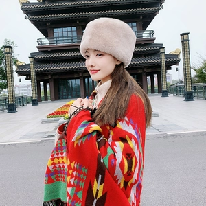 Detail of warm beige faux fur winter hat and red ethnic shawl with geometric patterns