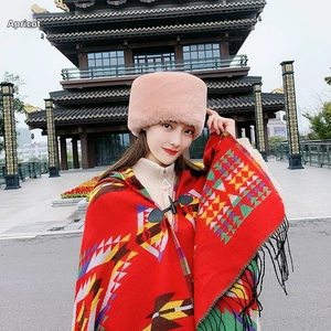 Detail of plush apricot faux fur winter hat paired with a red ethnic style hooded shawl