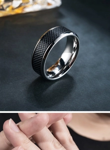 Detail view of men's stainless steel ring showing silver edges and black textured inner band