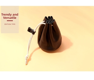 Detail of black pebbled leather drawstring pouch with cream cotton rope and leather toggle