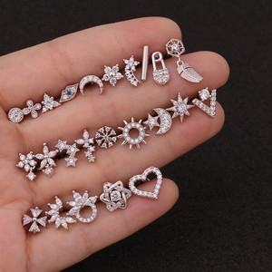 Macro detail of silver stainless steel stud earrings set with sparkling zircon in various shapes