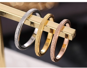 Detailed macro view of frosted tricolor stackable rings on a T-bar jewelry stand