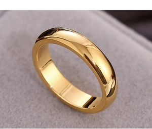 Macro view of gold minimalist titanium steel ring showing polished surface texture
