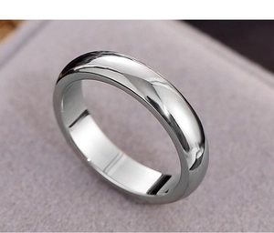 Macro view of a polished silver stainless steel ring on soft velvet fabric background