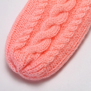 Detailed close-up of pink cable knit pattern on warm winter gloves for women