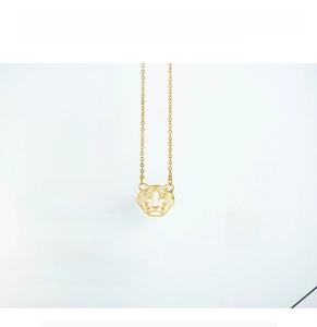 Detailed close-up of hollow tiger head pendant on a gold stainless steel chain necklace