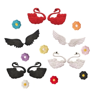 Close-up of embroidered swan and wing patches with colorful floral fabric details