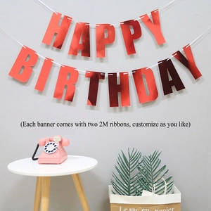 Metallic red Happy Birthday banner hanging over a minimalist table setting for party decor