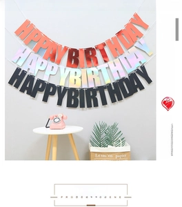 Three-color Happy Birthday banner set in orange, laser, and black cardstock hanging on a wall