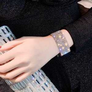 Close-up of wide silver-tone bracelet with rows of sparkling crystals on a model wrist