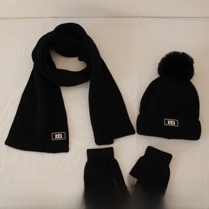 Detail of black knitted kids winter set featuring a soft scarf, beanie, and touch gloves