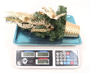 Close-up of artificial Christmas tree decoration with green needles and gold berries