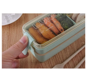 Close-up of a hand opening a blue wheat straw lunch box with eco-friendly cutlery