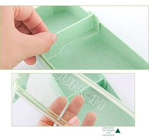 Detail of square wheat straw lunch box showing adjustable dividers and leak-proof clear lid