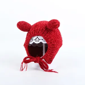 Detailed close-up of red knit baby winter hat with cute 3D bear ears and chin straps