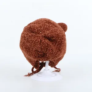 Close-up of the plush brown chenille texture and cute bear ear design on a winter hat