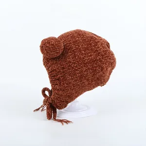 Detailed knit texture and pom-pom of a brown thermal bear ear winter hat for kids