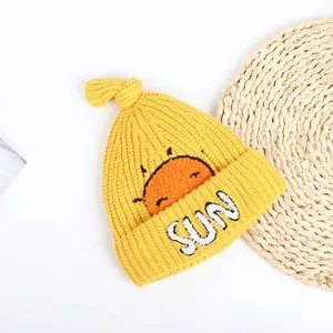 Detailed knit texture of a yellow baby sun hat with embroidered SUN patch