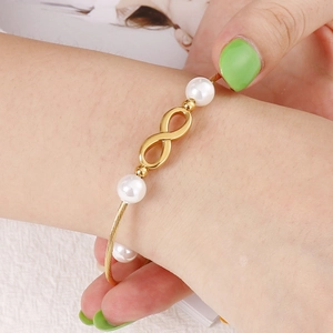 Bracciale simbolo infinito in oro con perle indossato sul polso regalo per donna