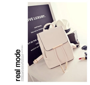 Zaino in ecopelle beige con finiture dorate e coulisse su una scrivania bianca