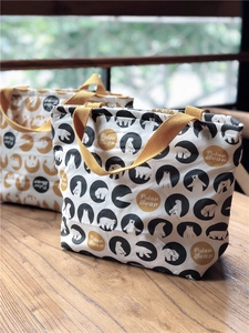 Détail de sacs à lunch en toile avec motifs d'ours polaires et anses jaunes sur bois