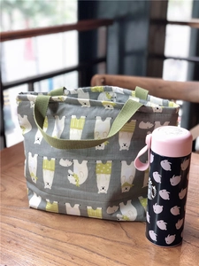 Détail du sac à lunch isotherme avec imprimé ours polaire et poignées vertes