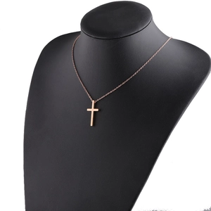 Macro shot of polished rose gold cross pendant on a minimalist O-chain with mirror finish
