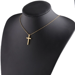 Detailed view of a minimalist golden stainless steel cross pendant on a black neck model