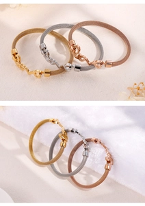 Detailed view of mesh steel bangles in gold, silver and rose gold with heart charms