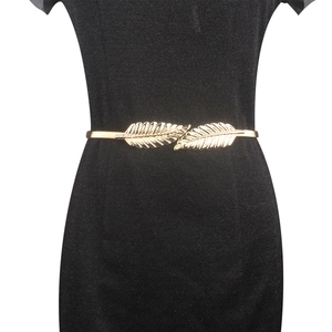 Detailed close-up of golden metal leaf buckle on a stretchy waist chain for dresses