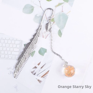Detail of silver feather bookmark with orange gypsophila dried flower glass ball pendant