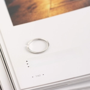 Minimalist S925 sterling silver thin line open ring on an artistic book background