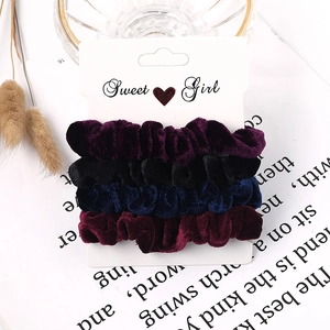Detail of velvet scrunchies set in four deep colors on a white display card