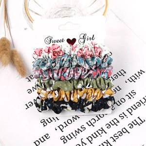 Set of six floral and polka dot fabric scrunchies displayed on a sweet girl card board