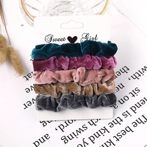 Detail view of 5-piece velvet scrunchies set in elegant candy colors on a display card