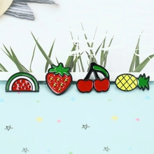 Dettaglio di spille in smalto a forma di frutta con anguria, fragola, ciliegia e ananas