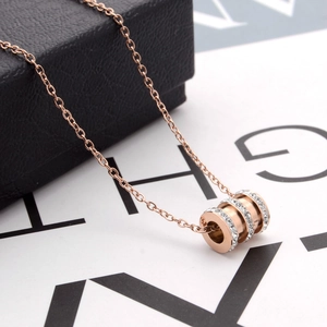 Detail of rose gold triple ring pendant with crystal pavé on a jewelry box display