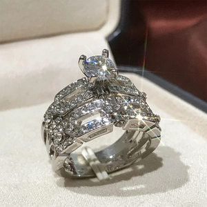 Makro-Detail des luxuriösen 4-Krallen-Hochzeitsring-Sets mit funkelnden CZ-Steinen in Silber