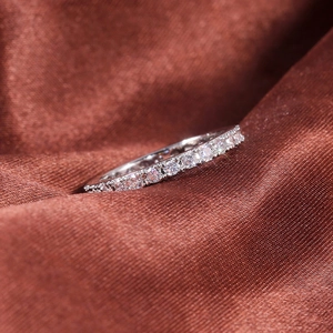 Gros plan d'une bague éternité en argent sertie de zircons sur soie marron
