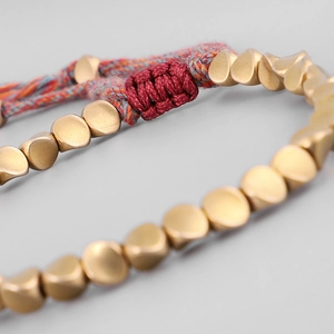 Pulsera tejida a mano con cuentas de latón dorado y cierre de borla ajustable suave