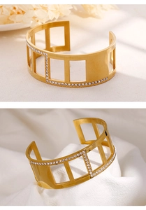 Detail of gold-plated striped open bangle featuring geometric cutouts and white rhinestones