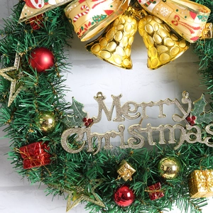 Gros plan d'une couronne de Noël verte avec cloches dorées et inscription Merry Christmas