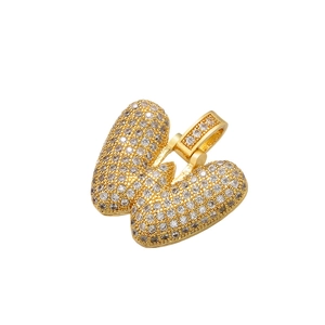 Detailed view of hip hop gold pendant with pavé-set clear stones and large bail