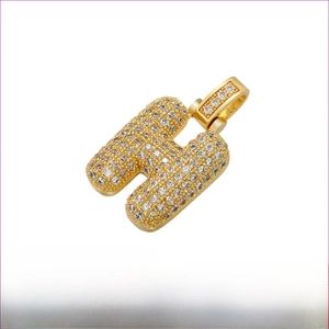 Macro detail of iced-out letter H pendant in gold finish with brass material specifications