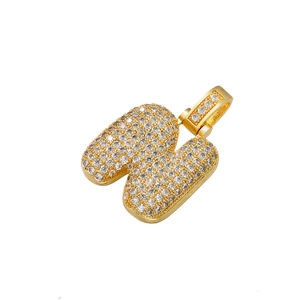 Detailed view of a gold-plated iced-out letter N pendant with cubic zirconia stones